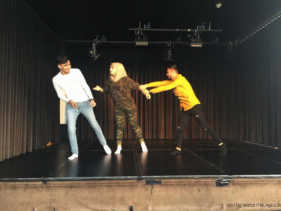 Drei Jugendliche spielen auf der Bühne Theater.